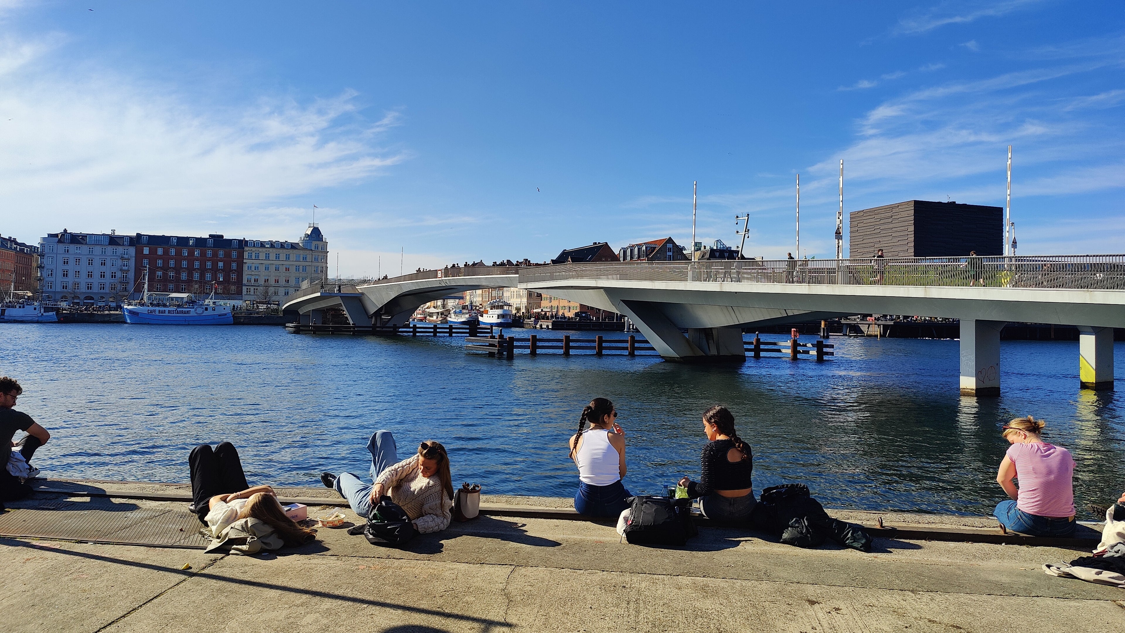 A group of people sitting by the water in Denmark